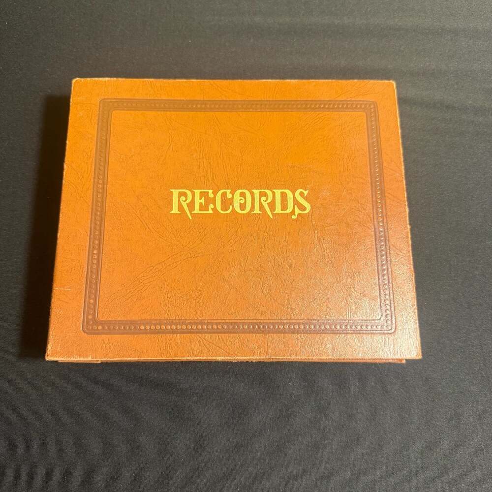 Vintage 45 RPM Vinyl Record Collection in Brown Leather-Style Storage Album